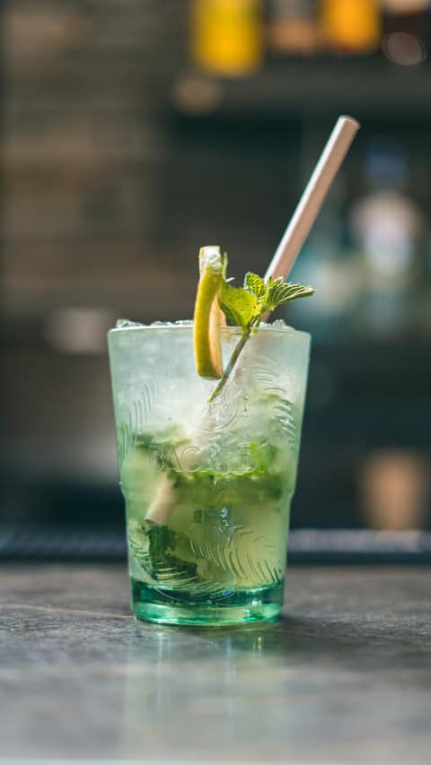 A mojito packed with fresh mint on the marble bar
